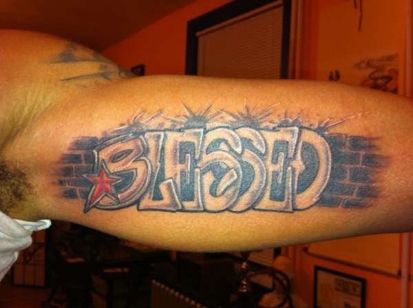 Grey shaded simple blessed tattoo on left bicep for men