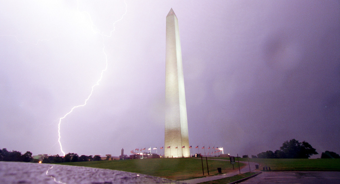 a lightning bolt is seen behind the washington monument