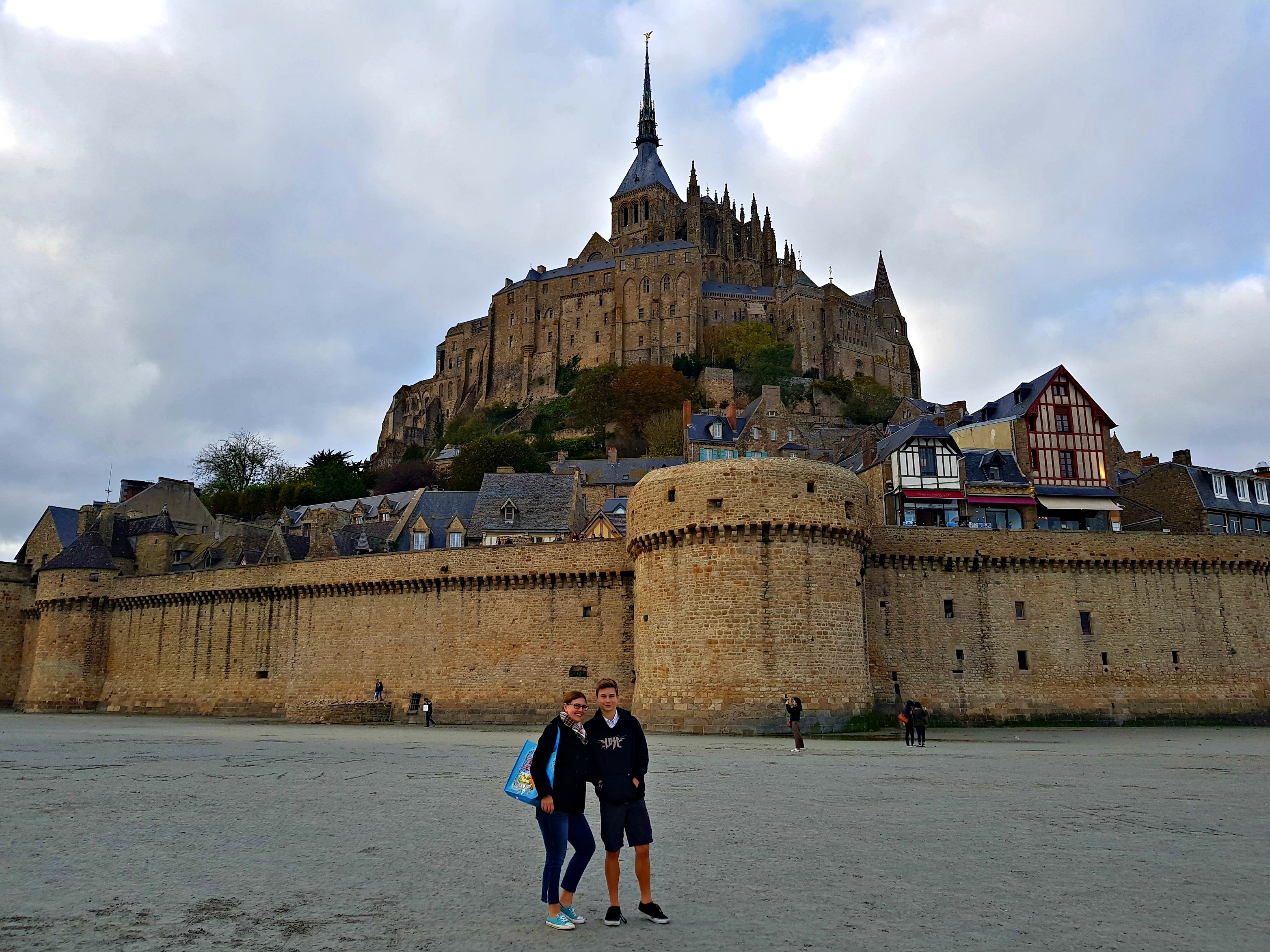 couple posing for photograph in front of mont st. michel