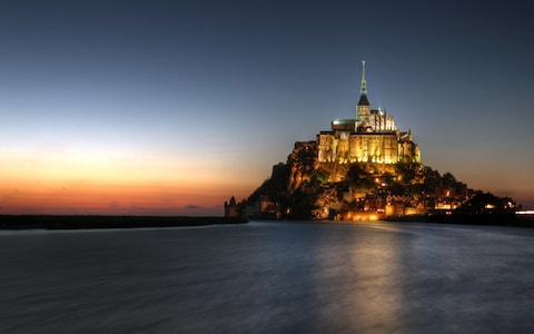 mont st. michel lit up at night