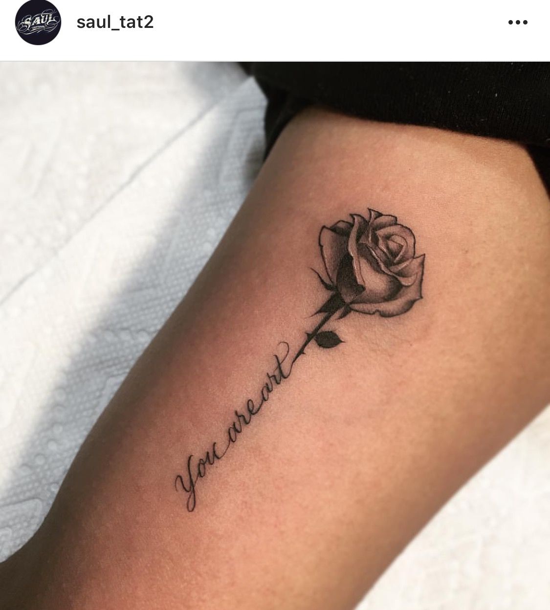 Black shaded small rose tattoo on inner forearm