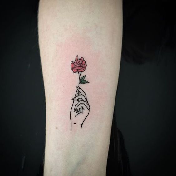 Red and green small rose and hand tattoo on mid inner arm