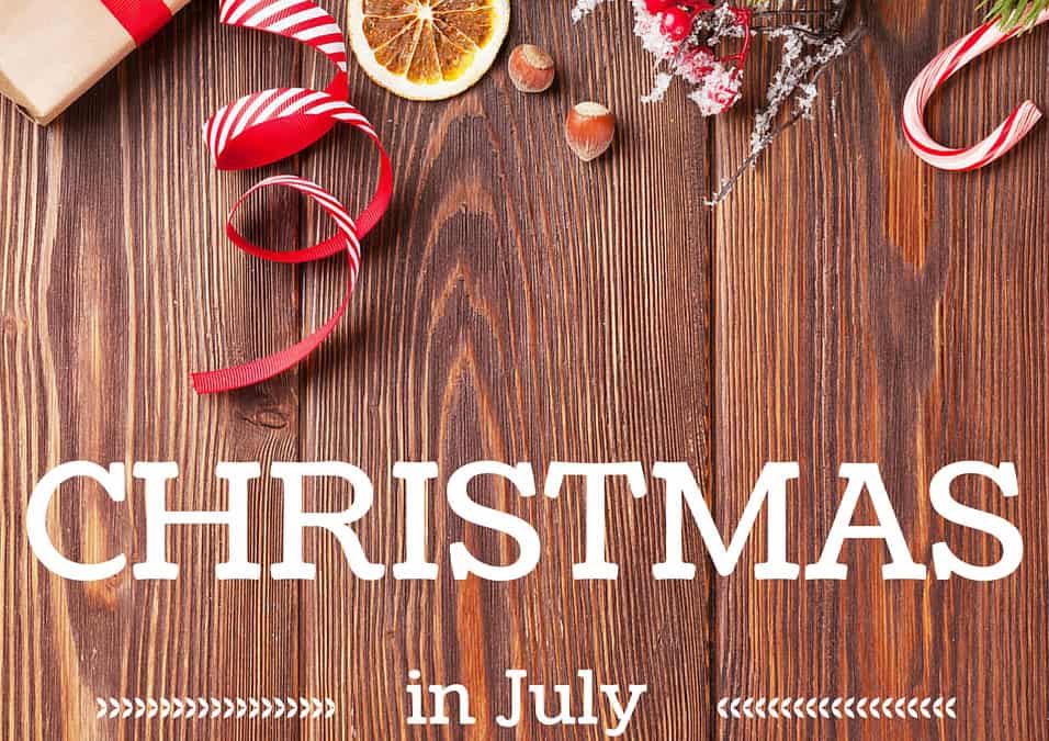 christmas in july wishes text on wooden background