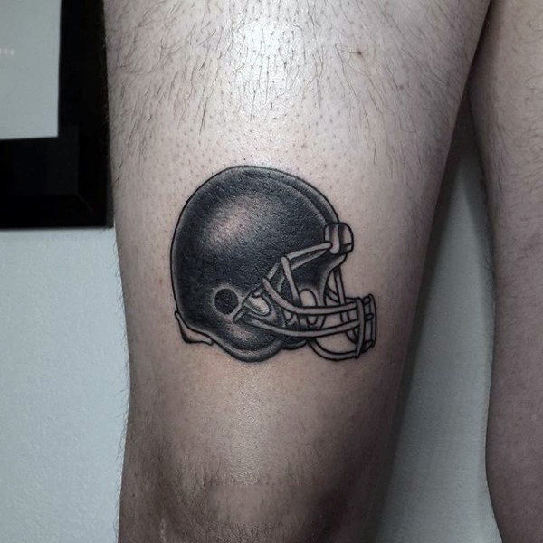 American football helmet tattoo on men's thigh
