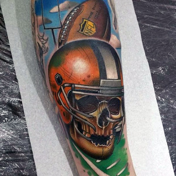 Colorful skull with footbal helemet tattoo on mens sleeve