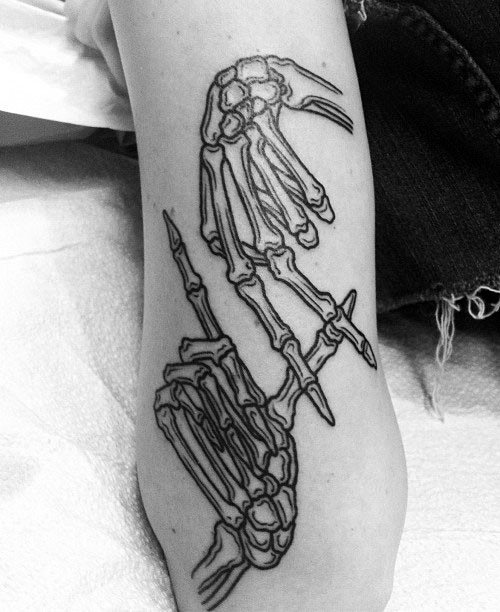 Black Ink Skeleton Hands Tattoo on Girl’s Arm