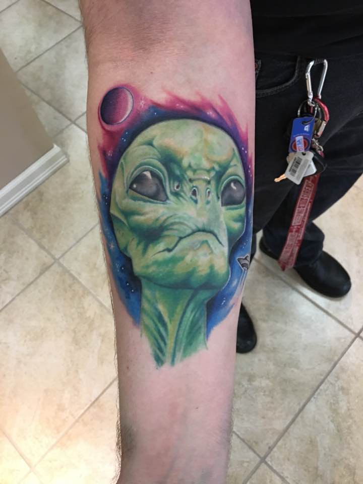 Amazing colorful alien tattoo on forearm